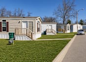 Thumbnail 5 of 8 - A row of mobile homes with a car parked in front of the first one.