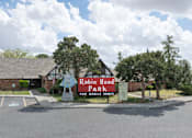 Thumbnail 1 of 8 - A sign for Robin Hood Park for mobile homes stands in front of a building.