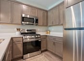 Thumbnail 2 of 10 - A kitchen with a stove, microwave, and refrigerator at Ventura Townhouses, West Olive  , 49460
