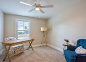 Thumbnail 9 of 10 - A room with a blue chair and a wooden table at Ventura Townhouses, West Olive  , 49460