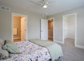 Thumbnail 7 of 10 - A bedroom with a bed in the center and a ceiling fan above it at Ventura Townhouses, West Olive  , MI, 49460