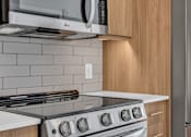 Thumbnail 66 of 109 - Modern kitchen with black stove at Altaire at Jackson Park, Seattle