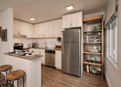 Thumbnail 37 of 41 - A modern kitchen with a stainless steel refrigerator and wooden bar stools