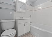 Thumbnail 29 of 41 - A white toilet sits next to a sink in a bathroom.