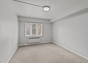 Thumbnail 27 of 41 - A room with a window and a carpeted floor