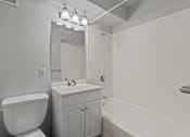 Thumbnail 22 of 41 - A white bathroom with a toilet, sink, and bathtub