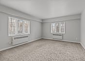 Thumbnail 24 of 41 - A room with a carpeted floor and two windows.