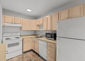 Thumbnail 15 of 41 - A kitchen with a white refrigerator, white oven, and wooden cabinets