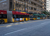 Thumbnail 14 of 41 - A red and yellow bus is parked on the side of the street