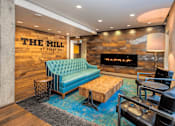 Thumbnail 2 of 41 - A blue sofa sits in front of a stone wall with a fireplace