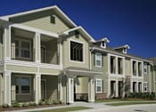 Thumbnail 12 of 22 - A row of townhouses with balconies and front yards.