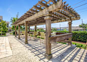 Thumbnail 5 of 22 - A wooden pergola with a bench underneath it.