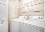 Thumbnail 4 of 22 - A white washer and dryer in a laundry room.