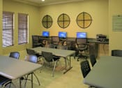 Thumbnail 14 of 22 - A room with tables and chairs and computers on the wall.