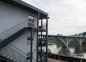 Thumbnail 5 of 17 - A bridge over a river with a house and stairs in the foreground.at Maplehurst Apartments, Knoxville, 37902
