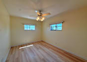 Thumbnail 8 of 12 - A room with wooden flooring and a ceiling fan.