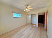 Thumbnail 7 of 12 - A room with a ceiling fan and a window.