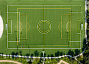 Thumbnail 10 of 21 - A soccer field with players on it.