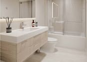 Thumbnail 7 of 18 - A modern bathroom with a white sink and a toilet.