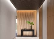 Thumbnail 2 of 18 - A long hallway with a plant on a table in the middle.