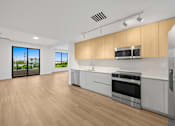 Thumbnail 4 of 21 - A modern kitchen with wooden cabinets and stainless steel appliances.