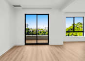 Thumbnail 19 of 21 - A room with a view of the city through a large window.