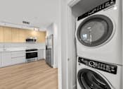 Thumbnail 6 of 21 - A modern laundry room with a washer and dryer.