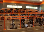 Thumbnail 17 of 18 - A gym with orange railing and exercise bikes.