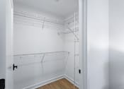 Thumbnail 11 of 34 - a closet with white walls and white shelves and a white closet door