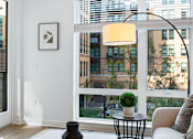 Thumbnail 31 of 34 - a living room with a large window and a view of the city