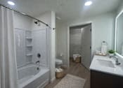 Thumbnail 20 of 30 - A bathroom with a white tub and sink.