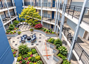 Thumbnail 2 of 14 - A courtyard with a fountain and a tree in the middle of it.