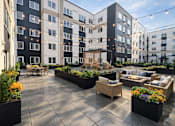 Thumbnail 27 of 30 - A courtyard with a table and chairs surrounded by buildings.