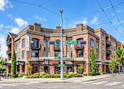 Thumbnail 1 of 14 - A street view of a building with a sign that says "ROY ST".
