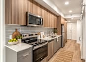 Thumbnail 5 of 51 - A modern kitchen with wooden cabinets and stainless steel appliances.