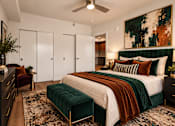 Thumbnail 11 of 51 - A bedroom with a large bed and a green velvet ottoman.