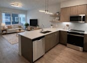 Thumbnail 6 of 30 - A modern kitchen with a large island and a microwave above it.