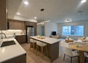 Thumbnail 1 of 30 - A modern kitchen with a dining table and chairs.