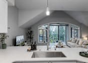 Thumbnail 5 of 14 - A modern kitchen with a large island and a sink.