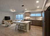 Thumbnail 9 of 30 - A modern kitchen with a bar area and a television.