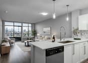 Thumbnail 7 of 14 - A modern kitchen with white cabinets and a large island.