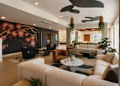 Thumbnail 29 of 30 - A living room with a large sofa set and a floral wallpaper.