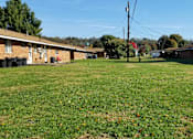 Thumbnail 6 of 12 - A grassy field with houses on the side.