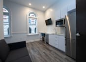 Thumbnail 20 of 20 - A kitchen with a refrigerator, microwave, and oven.