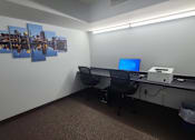 Thumbnail 31 of 37 - A room with a desk, computer, and pictures on the wall.