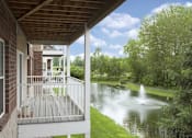 Thumbnail 3 of 37 - A house with a balcony overlooking a pond with a fountain.