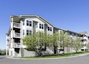 Thumbnail 33 of 37 - Apartment building with a clear blue sky above.
