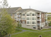 Thumbnail 37 of 37 - Apartment complex with a green lawn in front.