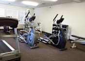 Thumbnail 9 of 37 - A gym with treadmill, exercise bike and other equipment.