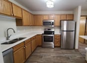 Thumbnail 14 of 37 - A kitchen with wooden cabinets and stainless steel appliances.